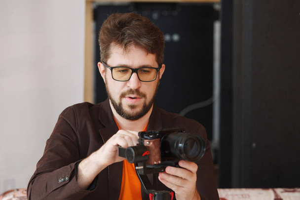 Photographer with glasses and a beard shoots at the camera - Фото, изображение