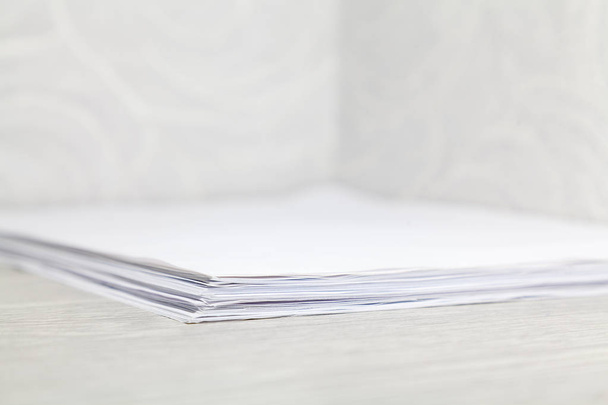 stack of paper sheets lies on the desktop in the corne - Photo, image