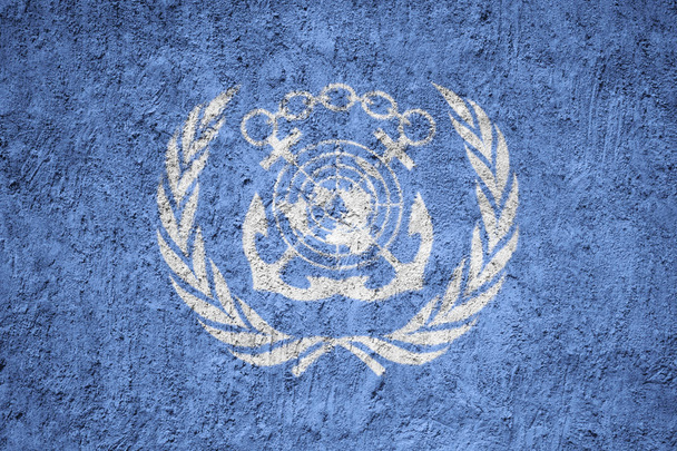 Flagge der Internationalen Seeschifffahrtsorganisation auf der Grunge-Betonwand - Foto, Bild
