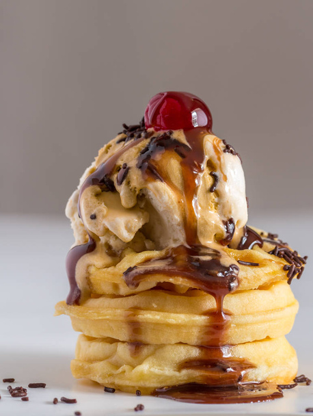 Вафли с тающим мороженым, шоколадный сироп, брызги и вишня сверху - вертикальное изображение
 - Фото, изображение