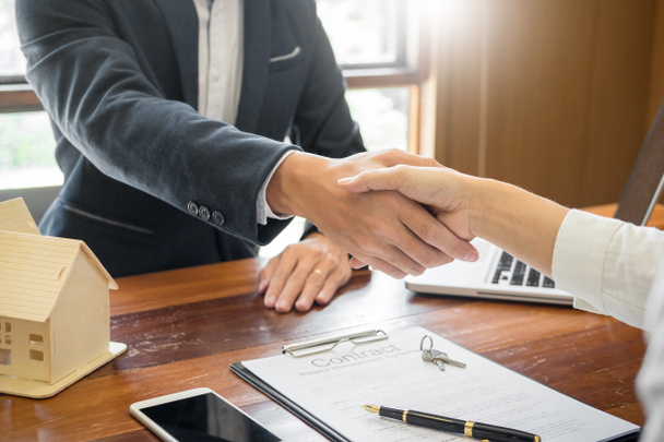Разработчик дома агент или финансовый консультант и клиенты пожимают друг другу руки после подписания сделки как успешное соглашение, контракт с фирмой
 - Фото, изображение