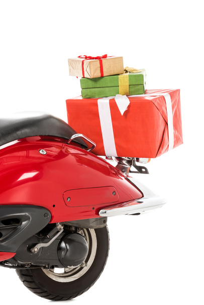 visão parcial de scooter vermelho com pilha de presentes de Natal isolado no branco
 - Foto, Imagem