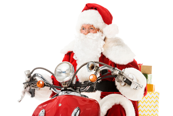 santa claus riding vintage red scooter with gift boxes and looking away isolated on white - Photo, Image