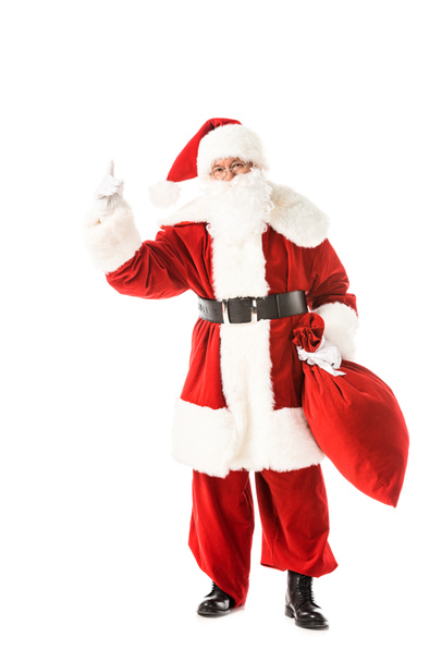 santa claus holding sack and pointing up while looking at camera isolated on white - Photo, Image