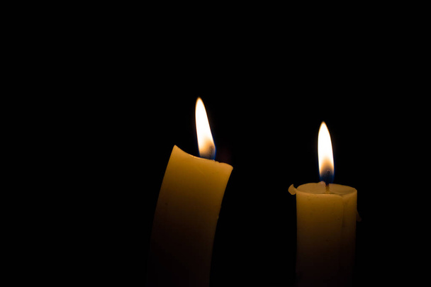 zwei brennende Kerzen auf schwarzem Hintergrund - Foto, Bild