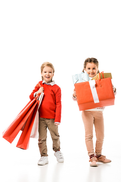 gelukkig weinig kinderen met papieren zakken en de giften van Kerstmis geïsoleerd op wit - Foto, afbeelding