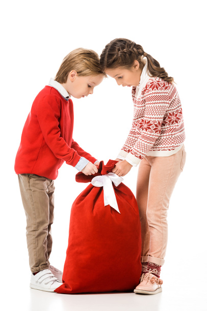 excited little kids looking at santa gift sack isolated on white - Foto, immagini