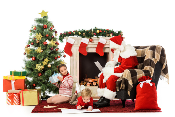 bambini disfare i regali e disegnare sul pavimento vicino a Babbo Natale in poltrona
 - Foto, immagini