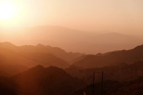 Sunset over layer of mountain ranges cause beautiful shades of red. Iran. - Photo, Image