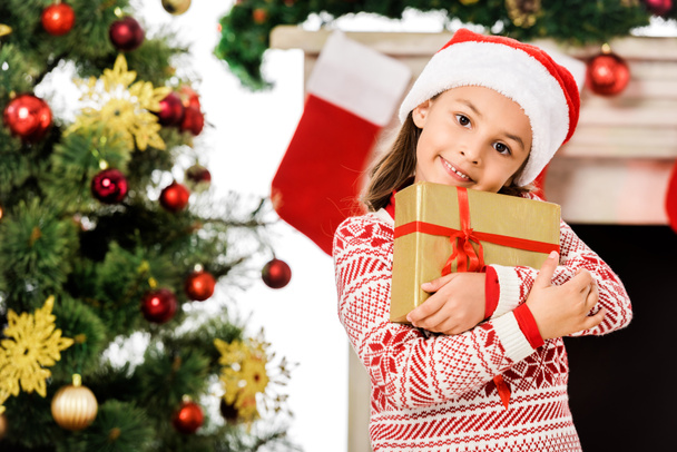 красива маленька дитина тримає різдвяний подарунок і дивиться на камеру
 - Фото, зображення
