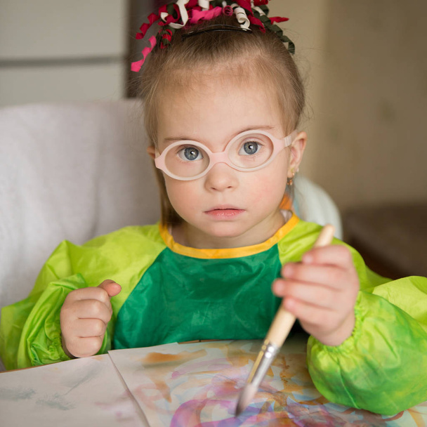 Chica con síndrome de Down cubierto de pintura al dibujar - Foto, imagen