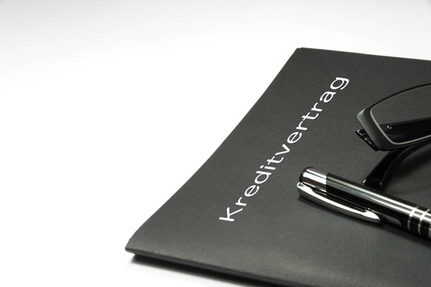 Un portefeuille avec un contrat de prêt, un stylo plume et une paire de lunettes
 - Photo, image