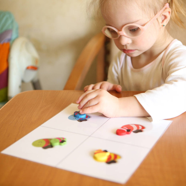 Girl with Down syndrome is involved in sorting - Photo, Image