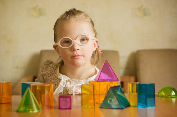 Chica con síndrome de Down jugando con formas geométricas
 - Foto, imagen