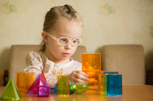 Girl with Down syndrome playing with geometrical shapes - Photo, Image