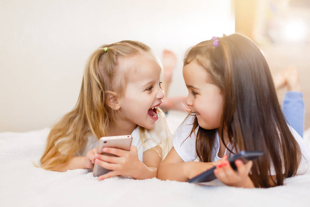 petites filles heureuses avec des smartphones couchés sur le sol à la maison
 - Photo, image