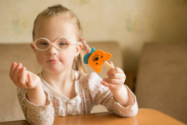 Chica con síndrome de Down jugando Animales de fieltro desarrollando habilidades motoras finas de los dedos
 - Foto, imagen
