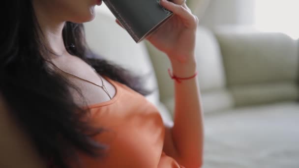 Woman drinking tea at home, relaxing, rest time, sitting on sofa - Video