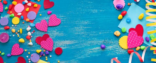 Banner Fondo decorativo de vacaciones con serpentinas confeti corazones de caramelo decoración. Azul pésimo vista superior de madera fondo plano laico
 - Foto, Imagen