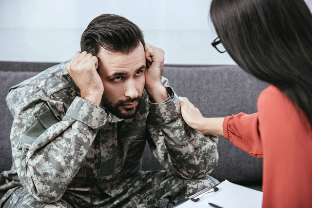 soldado deprimido con síndrome postraumático mirando al psiquiatra durante la sesión
 - Foto, Imagen