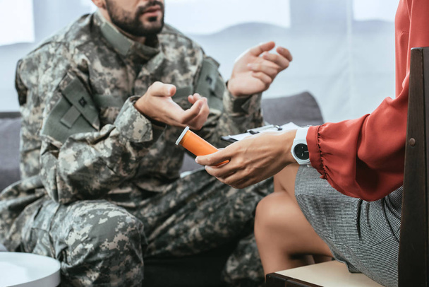 rajattu laukaus sotilas yhtenäinen ptsd puhu psykiatri terapiassa istunto, kun hän tilalla purkki pillereitä
 - Valokuva, kuva