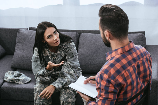 θυμωμένος γυναίκα στρατιώτη με ptsd μιλώντας σε ψυχίατρο θεραπευτική συνεδρία - Φωτογραφία, εικόνα