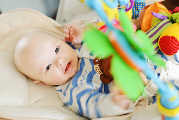 baby laying in bouncer chair and playing toy - Foto, Bild