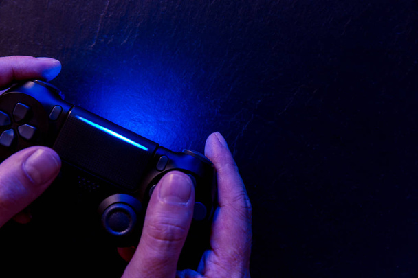 Homme jouant jeu vidéo avec contrôleur la nuit avec des lumières
 - Photo, image