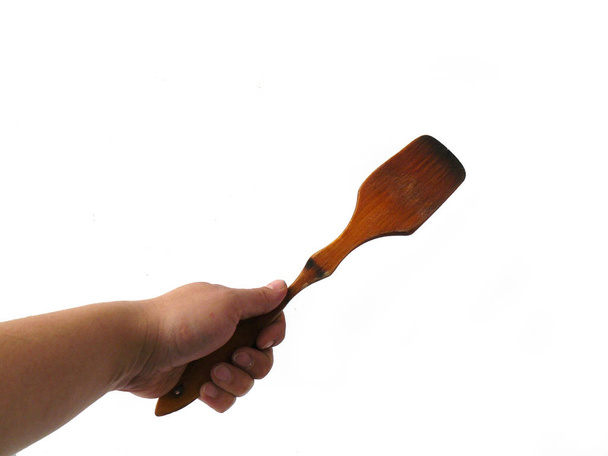 Kitchenware,  kitchen spatula in hand, wooden kitchen, wooden spoon,, utensils for cooking. Headstock stock image - Photo, Image