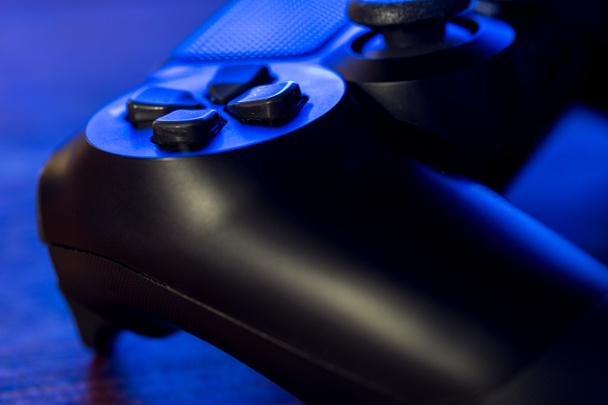 Weergave van video game controller met neon blauwe verlichting 's nachts sluit - Foto, afbeelding
