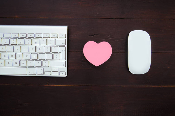 コンピューターのキーボード、ピンクのハートと木製オフィス デスクのワークスペース上でマウス - 写真・画像