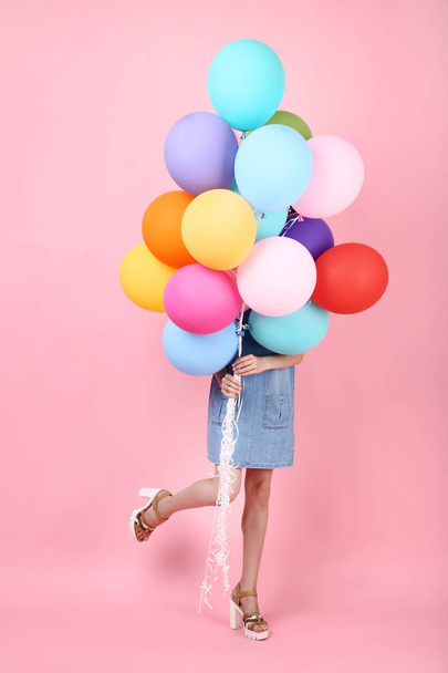 Młoda dziewczyna z kolorowych balonów na różowym tle - Zdjęcie, obraz