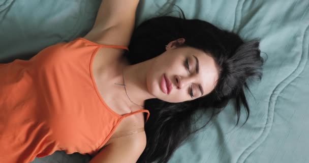 Woman wake up and stretches on bed, daytime sleep - Кадри, відео