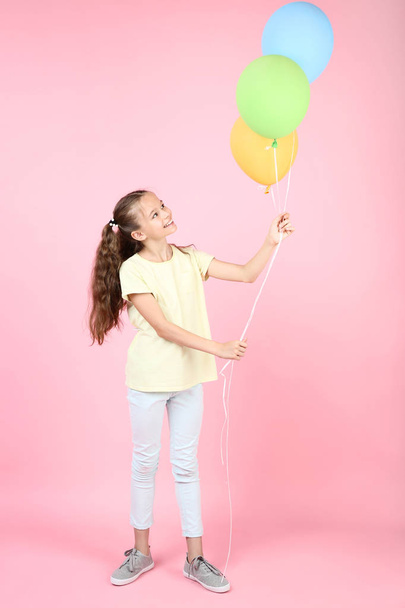 Cute young girl with colored balloons on pink background - Foto, Imagem
