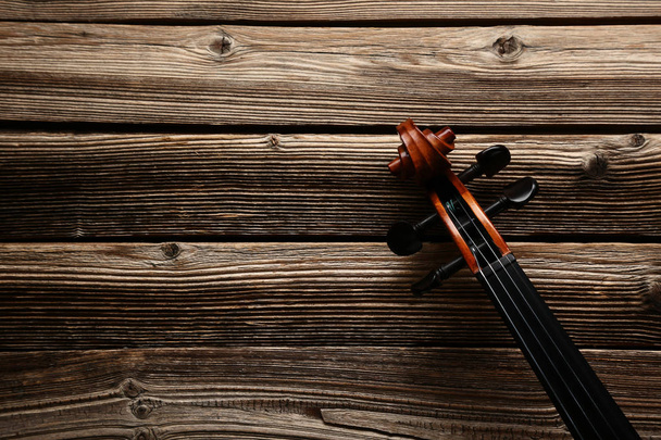 close-up of violin head on brown wooden table - Фото, зображення