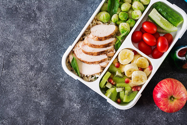 Sağlıklı yeşil yemek hazırlayın konteyner tavuk fileto, pirinç, Brüksel lahanası, sebze ve meyve gri taş zemin üzerine - Fotoğraf, Görsel