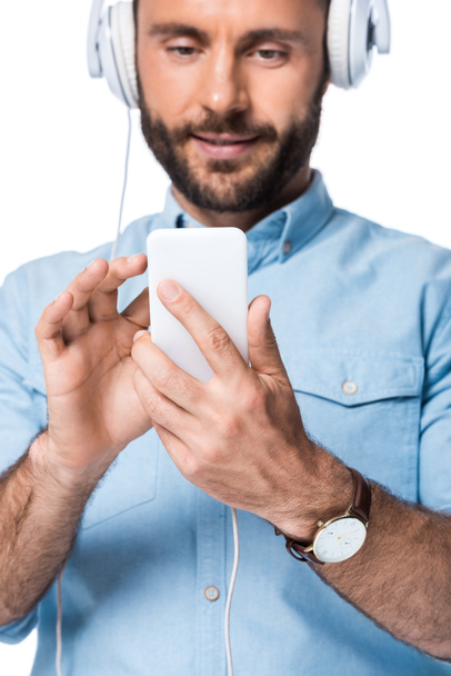 bearded man listening music and using smartphone isolated on white - Photo, Image