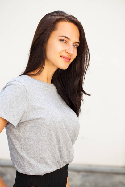 Happy Beautiful brunette woman in gray t-shirt, isolated on white wall background - Fotoğraf, Görsel