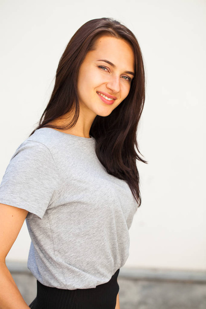 Happy Beautiful brunette woman in gray t-shirt, isolated on white wall background - Foto, immagini