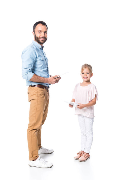 χαμογελά πατέρα και κόρη χρησιμοποιώντας ψηφιακές ταμπλέτες που απομονώνονται σε λευκό - Φωτογραφία, εικόνα
