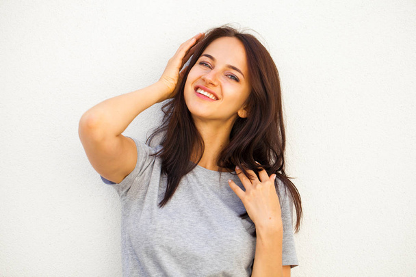 Happy Beautiful brunette woman in gray t-shirt, isolated on white wall background - Φωτογραφία, εικόνα