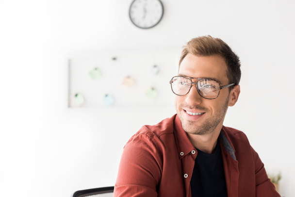 smiling businessman in glasses looking away  - Фото, изображение