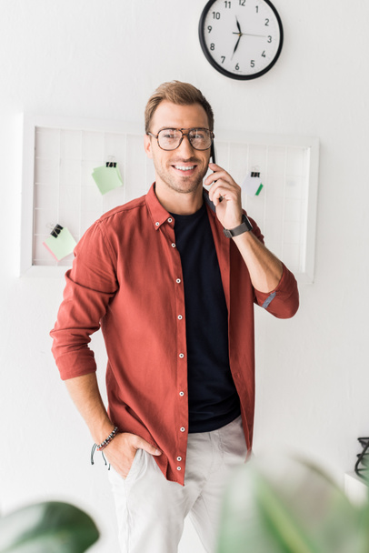 smiling businessman in glasses talking on smartphone - Photo, Image