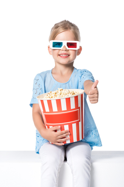Kid met 3D-bril en popcorn tonen duim geïsoleerd op wit - Foto, afbeelding