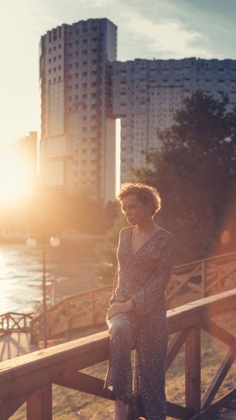 Close up portrait of a woman in a park on a warm summer day during the sunset - Photo, Image