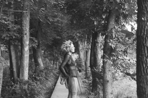 Retrato de una mujer con lencería y babydoll, riendo y mirando a un lado, fotografiado en un parque
 - Foto, Imagen