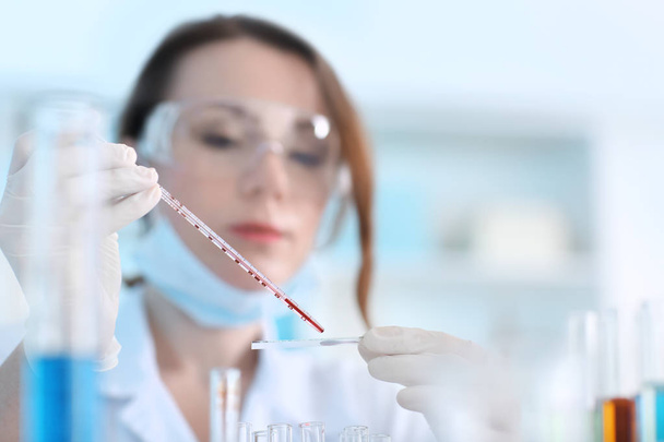 Ученый, работающий с образцом крови в лаборатории - Фото, изображение