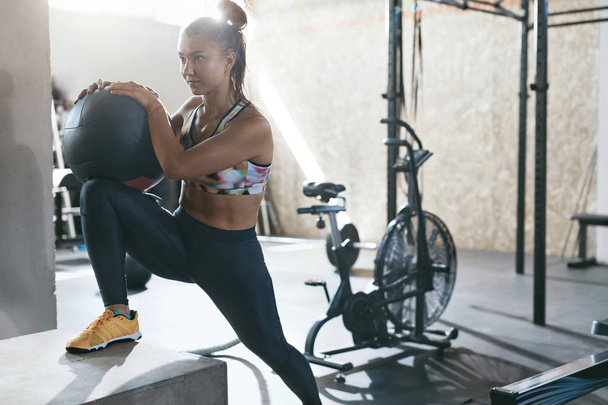 Sportswoman Training With Crossfit Ball On Box At Gym - Фото, изображение