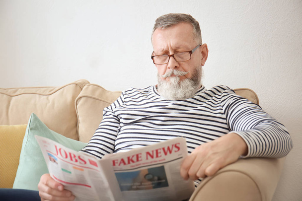 Hombre mayor leyendo el periódico en casa - Foto, imagen