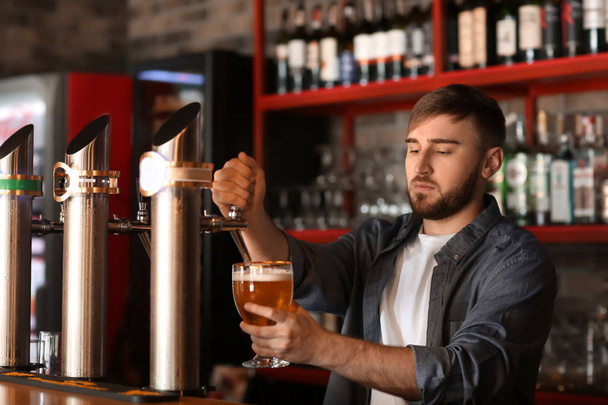 Nalewania piwa do szklanki barmana w barze - Zdjęcie, obraz